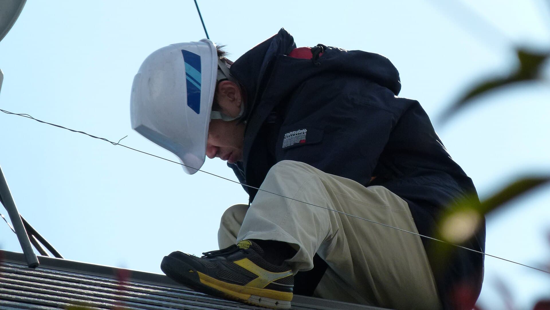 Technician fitting solar panels on a rooftop
